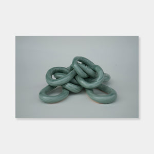 Artsuite - Sangsun Bae - Gordian Knot 1 - Sculpture - Ceramic -9" x 9" x 4"- Bae expresses herself through soft and graceful lines and interlocking curves.  By using organic forms, her work has a flowing elegance demonstrating complete abstraction.  This basic element in her work reflects the stoic style of expression that invokes ties to Buddhism.