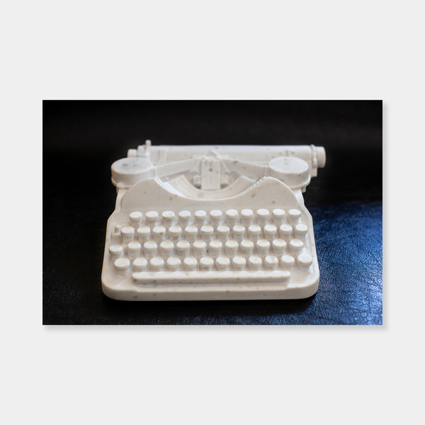 Artsuite - Peter Oakley - Typewriter - Original sculpture out of marble.  Oakley developed his carving skills working as a stonemason, making grave markers and memorials before turning to sculpture. In his hand, the marble sculpture becomes a solid ghost of what it represents—full of physical presence, but missing the functionality of the object.